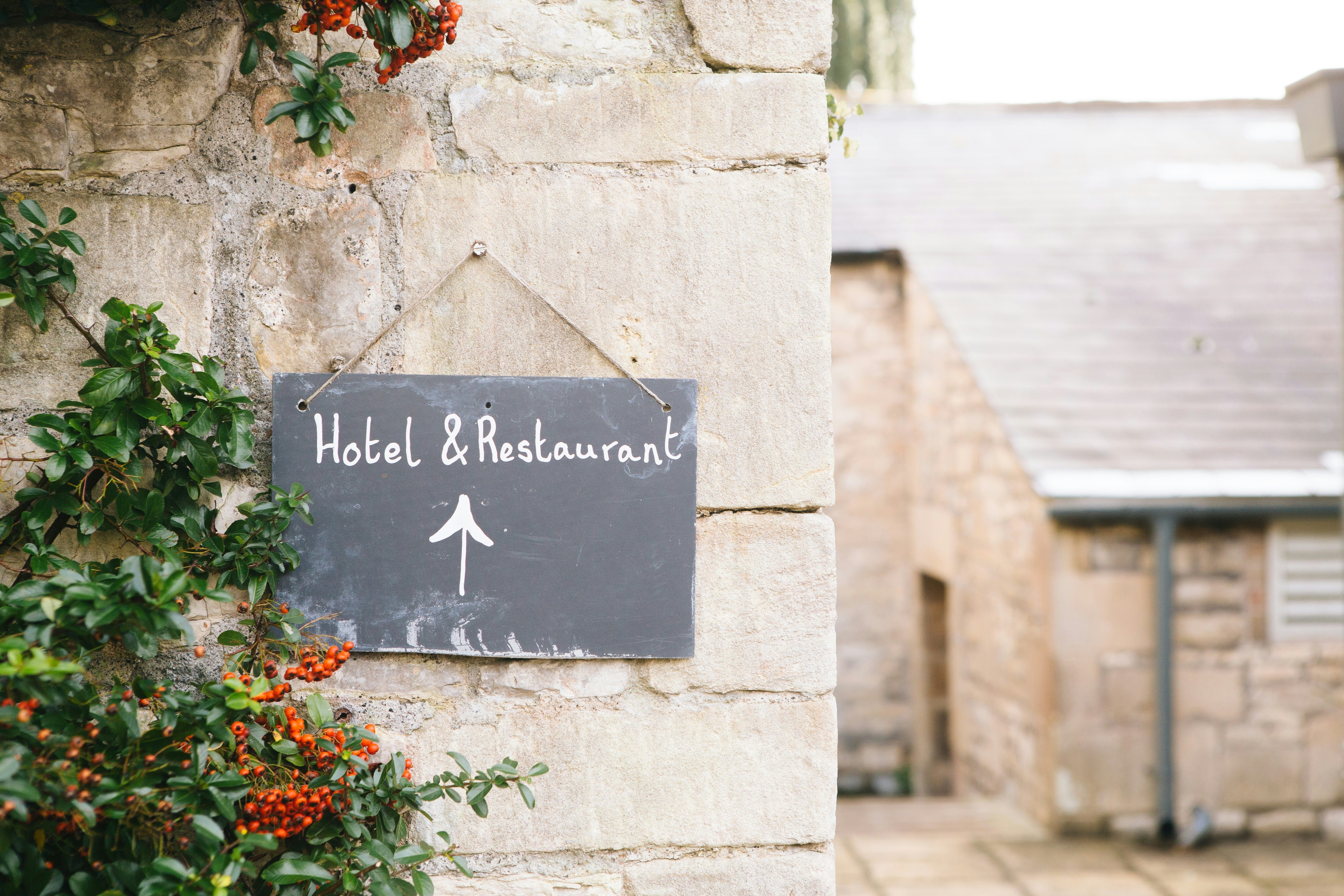 Sign for hotel and restaurant with directional arrow.