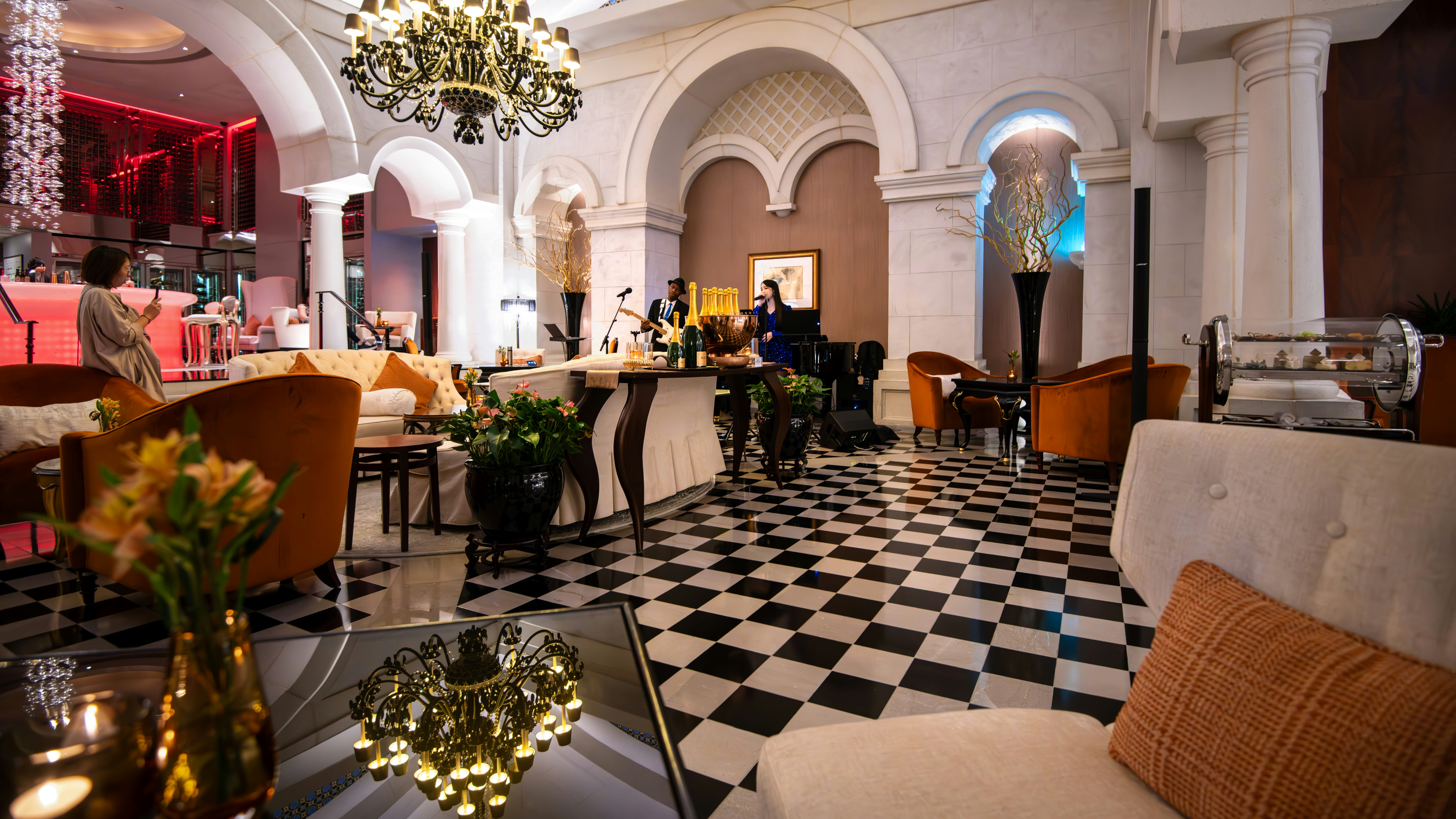 Elegant lounge with furniture and decorative chandelier.