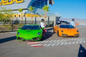Green and orange sports cars at racetrack.